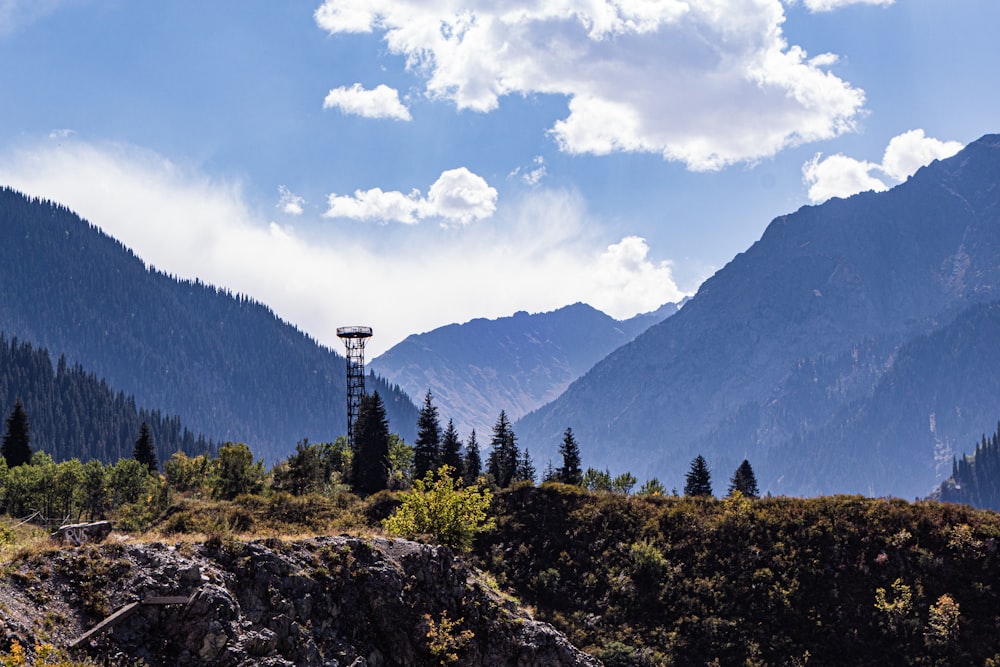 a view of a mountain range with a radio tower in the foreground