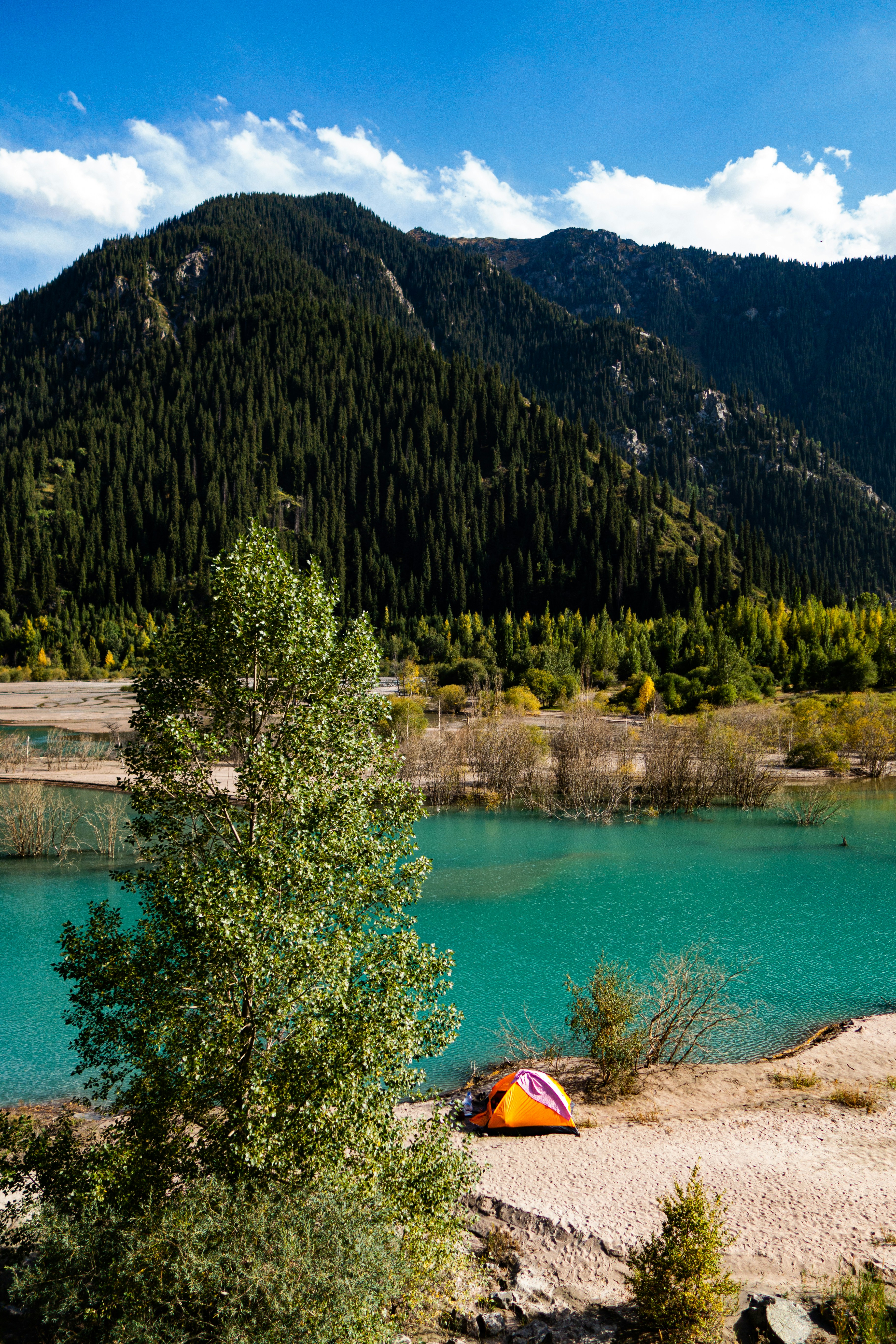 Una tienda de campaña en la orilla de un lago de montaña