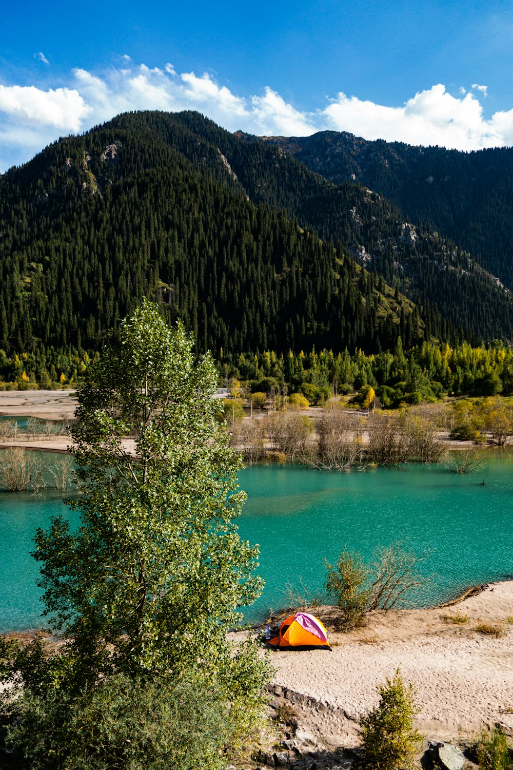 a tent on the shore of a mountain lake