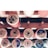 Spools of thread in varying colors are arranged on a wooden holder. Each spool is labeled with information about thread type and color. The arrangement is neatly organized and appears to be well-maintained.