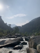 A serene mountain landscape with lush green forests and a winding river.