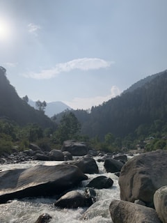 A serene mountain landscape with lush green forests and a winding river.