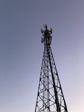 A tall communication tower silhouetted against a clear sky, showcasing tower design expertise.