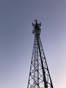 A tall communication tower silhouetted against a clear sky, showcasing tower design expertise.