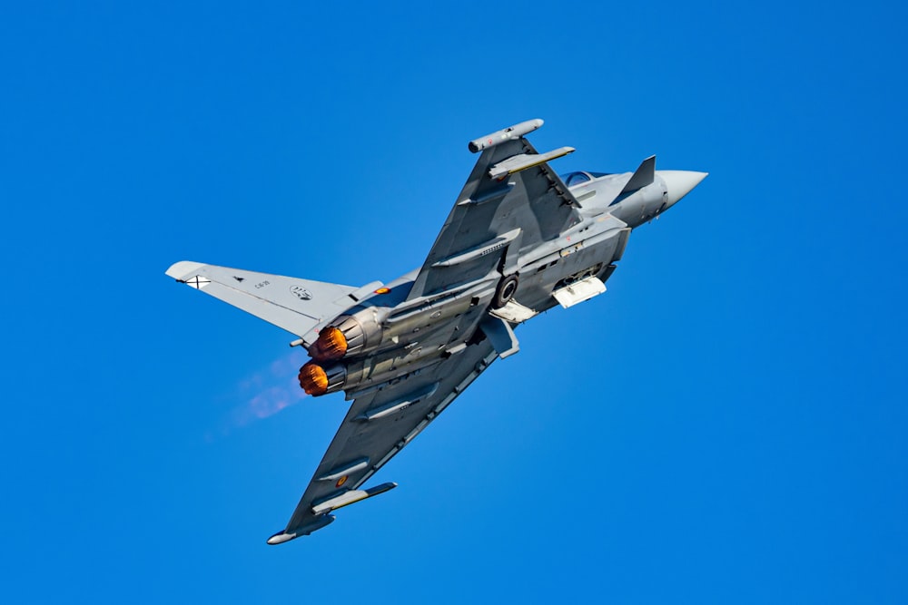 Un avión de combate volando a través de un cielo azul