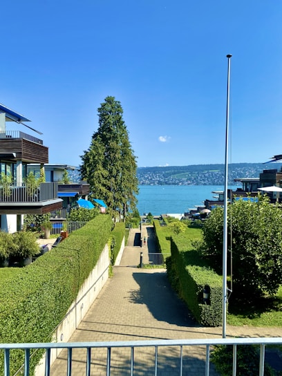 A serene residential plot with wide roads, green spaces, and clear blue skies.