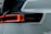 A close-up view of a car's rear light assembly featuring sleek, modern design. The light is illuminated with a bright red LED strip surrounding a dark, glossy housing. The word 'Polestar' is visible, suggesting the brand of the vehicle. The surrounding car body has a smooth, glossy white finish.