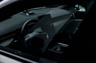 A modern car interior lit softly, highlighting the dashboard and steering wheel.