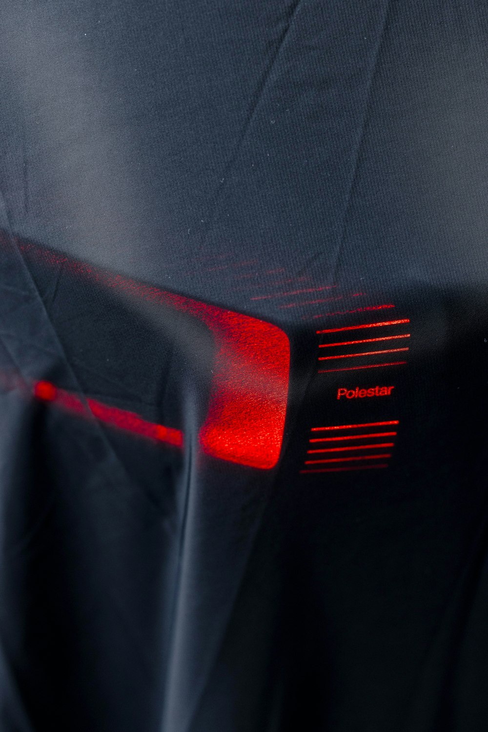 a close up of a black cloth with a red light on it