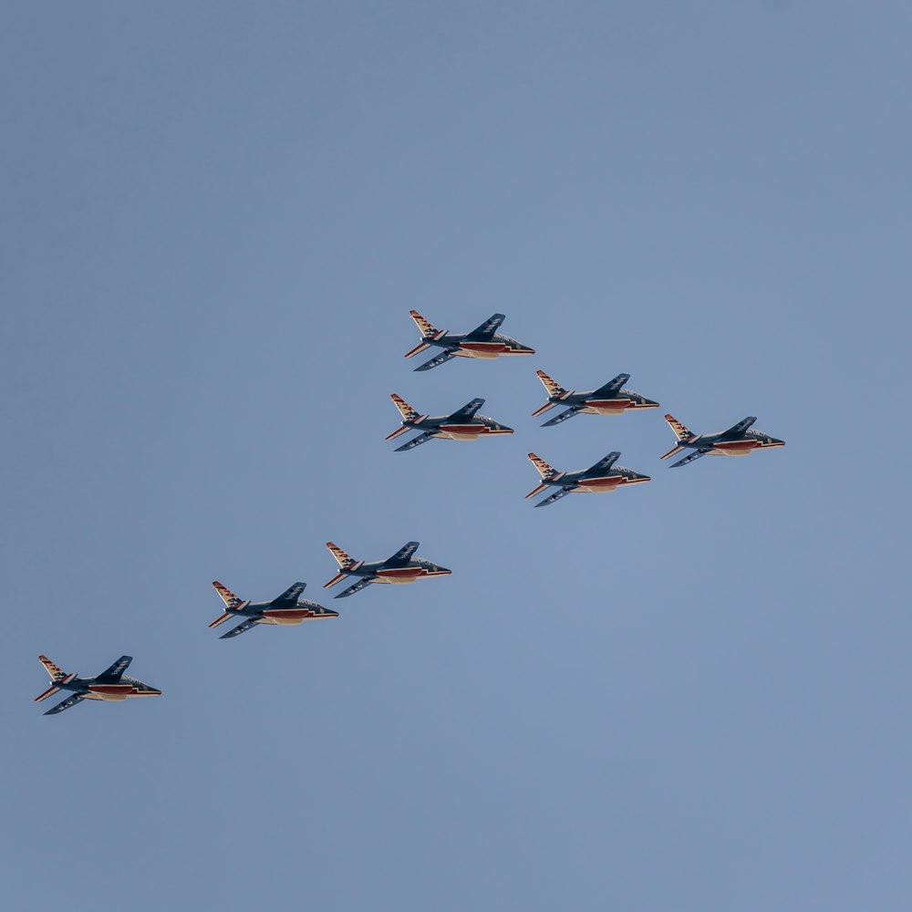 a formation of fighter jets flying through a blue sky