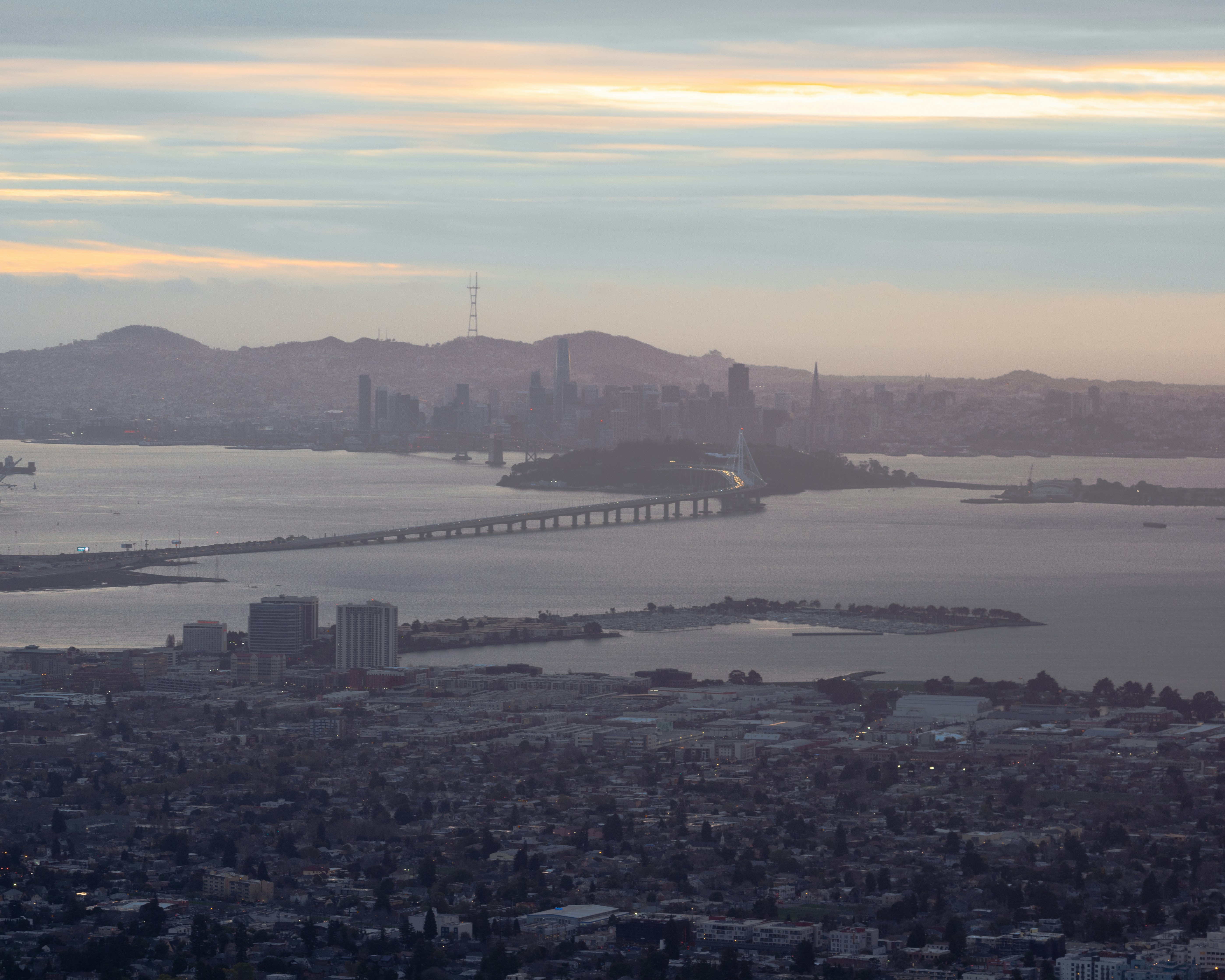 a large body of water surrounded by a city, San Francisco Hazy Sunset