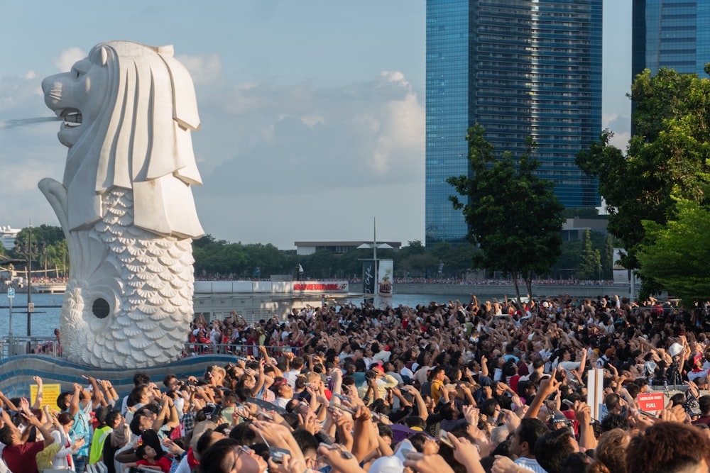 a crowd of people taking pictures of a statue