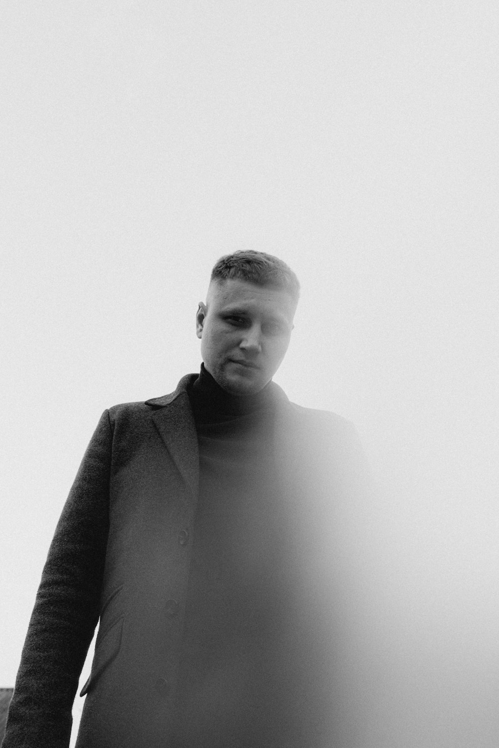 Una foto en blanco y negro de un hombre con un abrigo