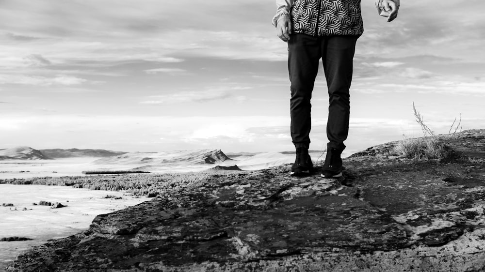 a man standing on top of a large rock