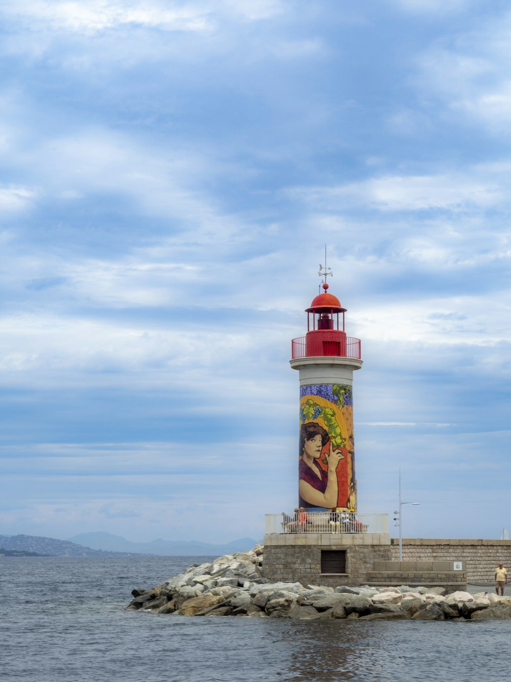 a red and white light house sitting on top of a pier