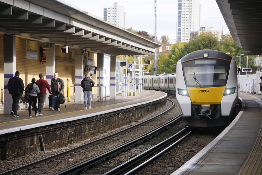 a yellow and white train pulling into a train station