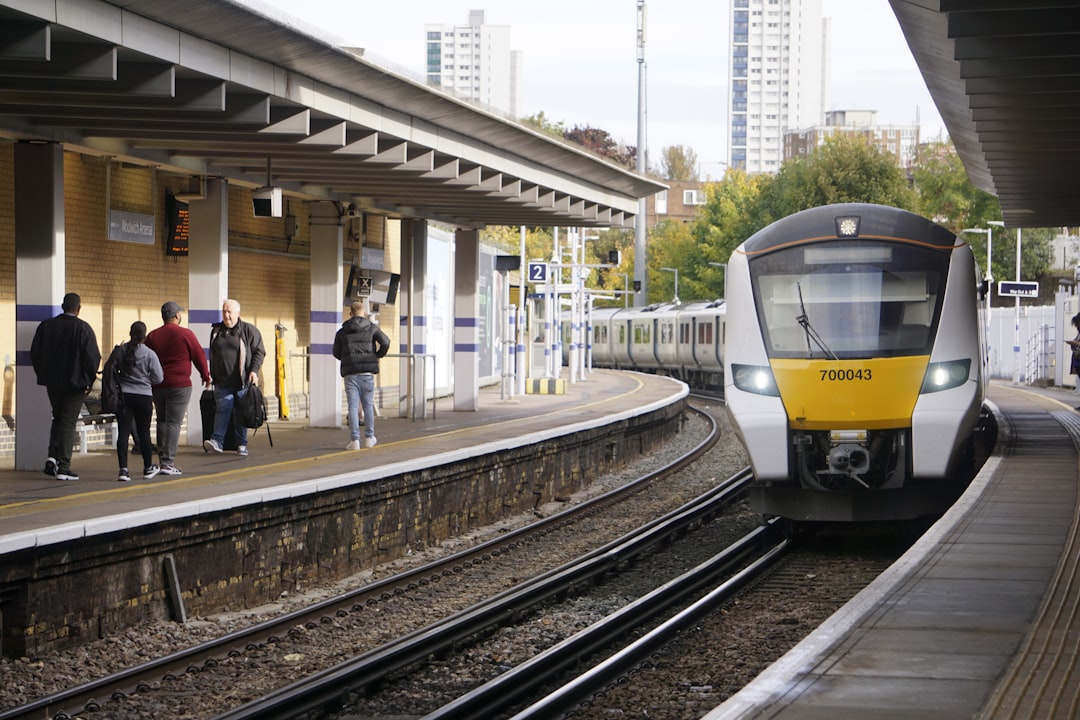 a yellow and white train pulling into a train station, A Thameslink Class 700