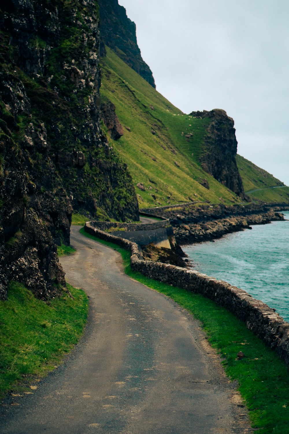 a winding road next to a body of water