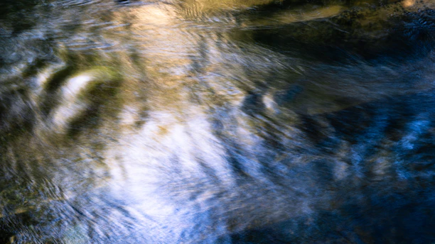 A serene image of flowing water illuminated by soft blue and magenta lights symbolizing vibrational energy.