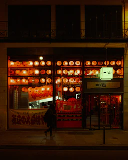 Evening view of the store’s exterior glowing softly under lantern light.
