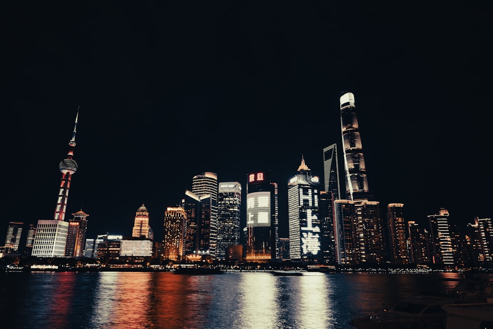 a city skyline at night with lights reflecting off the water