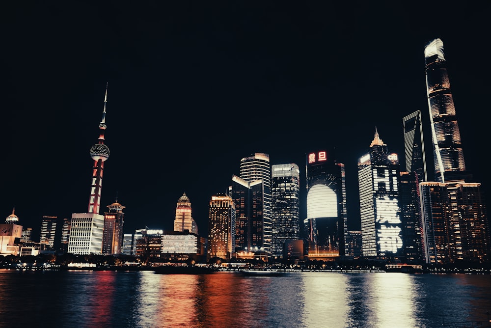 a city skyline at night with lights reflecting off the water