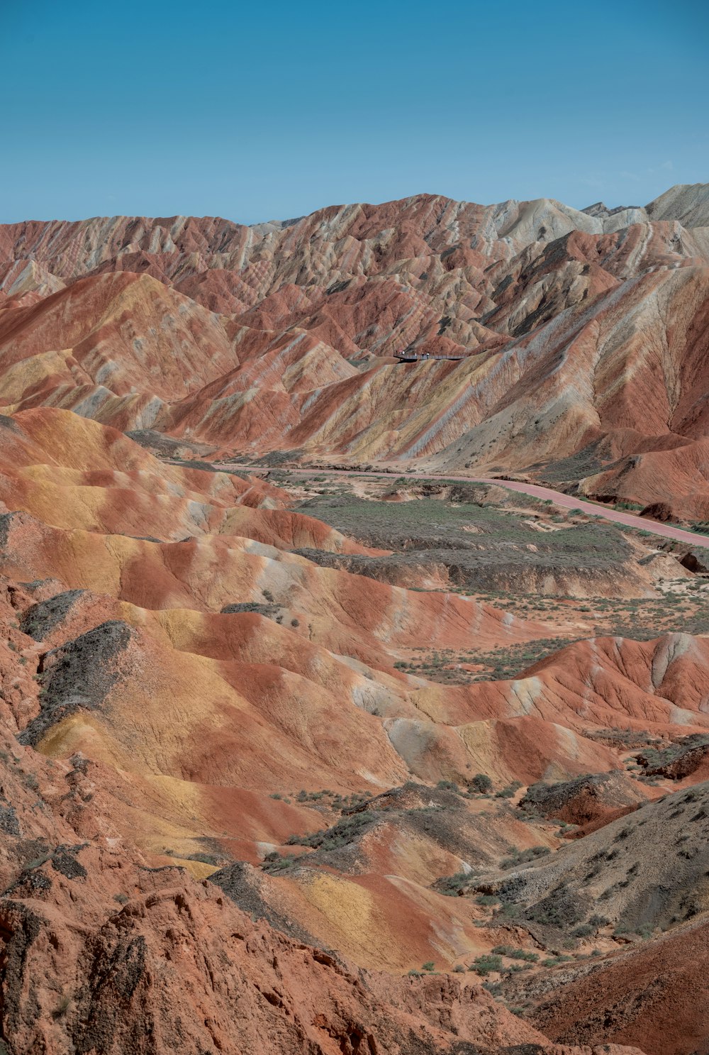 a scenic view of a mountain range with a road going through it