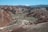 A foothills vista with layered sagebrush and charcoal-gray rocky outcrops beneath a clear blue sky.