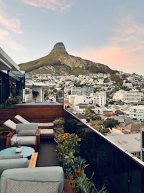 A panoramic rooftop terrace with comfortable seating and views of the Atlas Mountains at sunset.