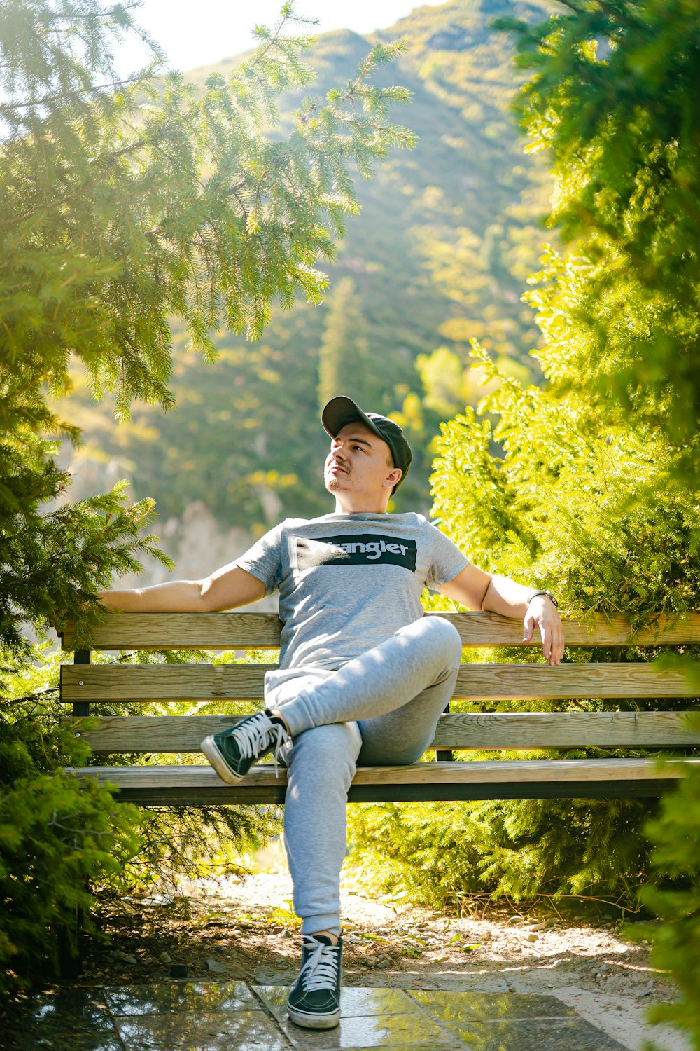 a man sitting on a wooden bench in the woods