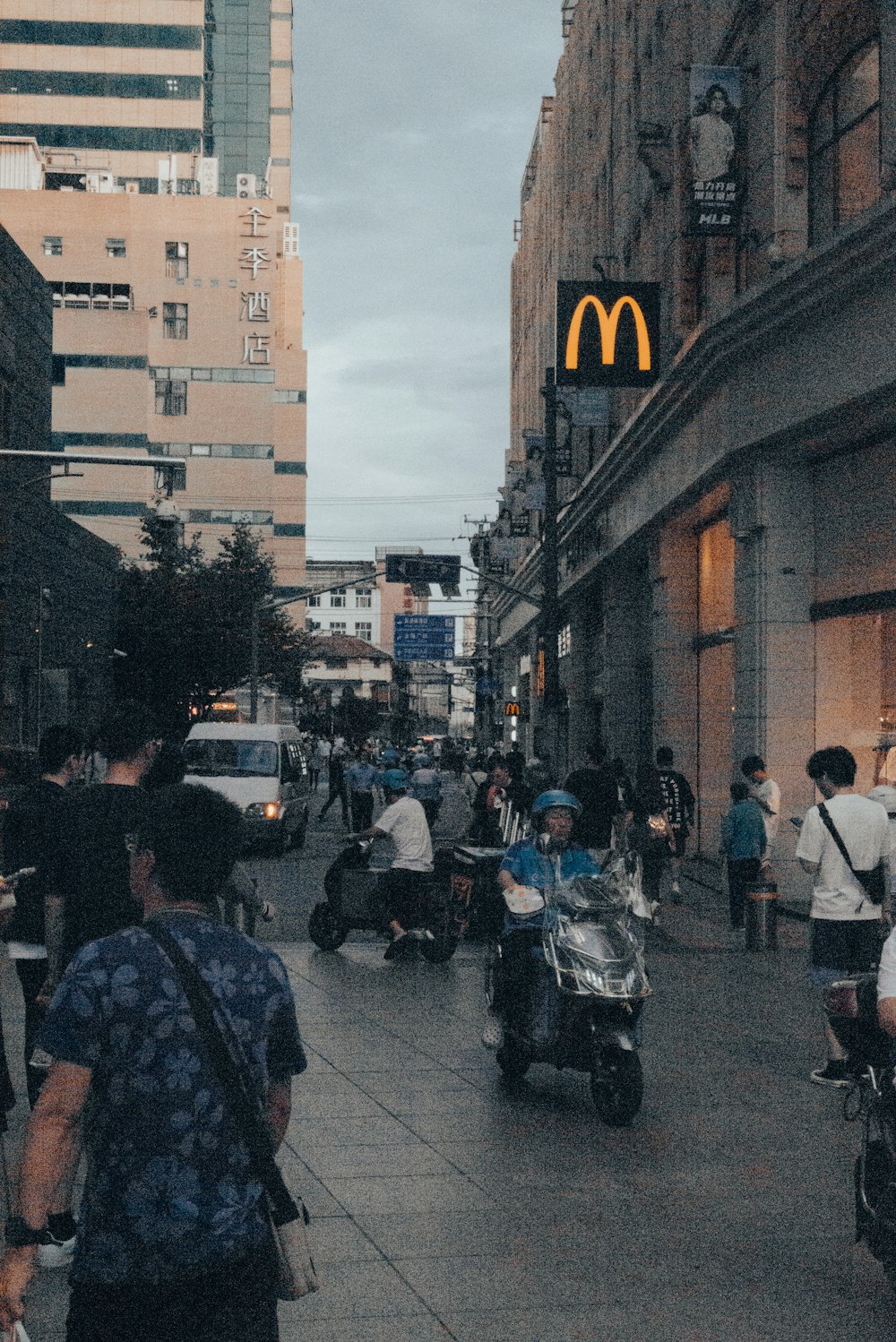 a group of people riding scooters down a street