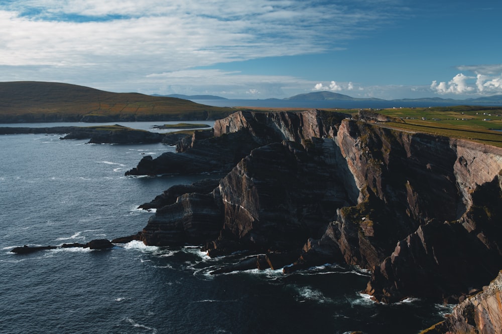 a large body of water next to a rocky cliff