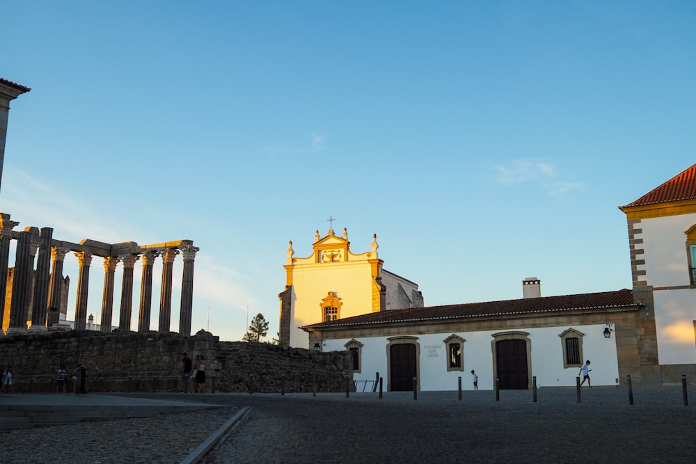 a building with columns and a clock tower in the background