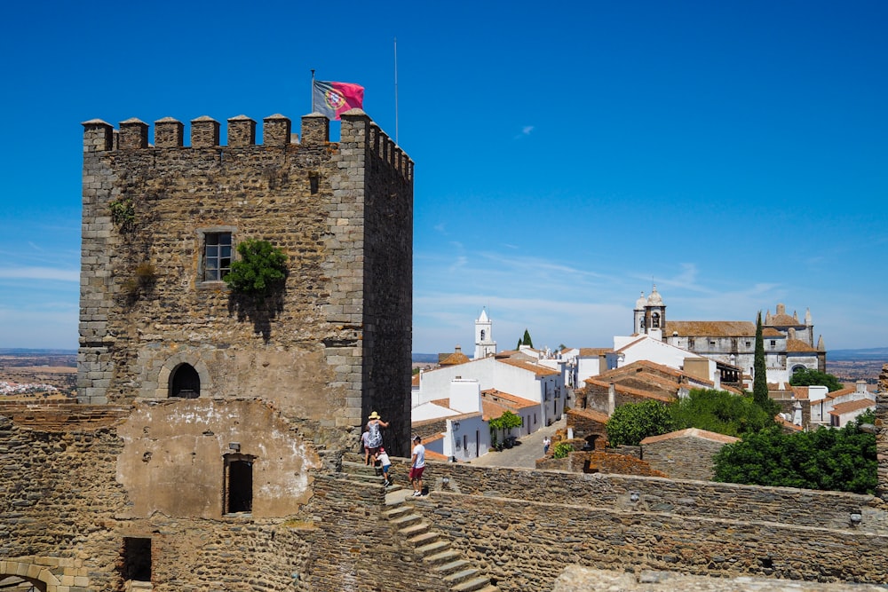 a couple of people standing on top of a stone building