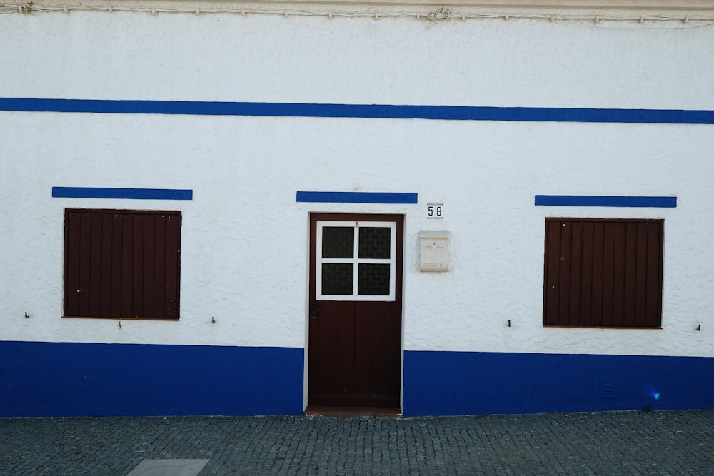 a white and blue building with a brown door