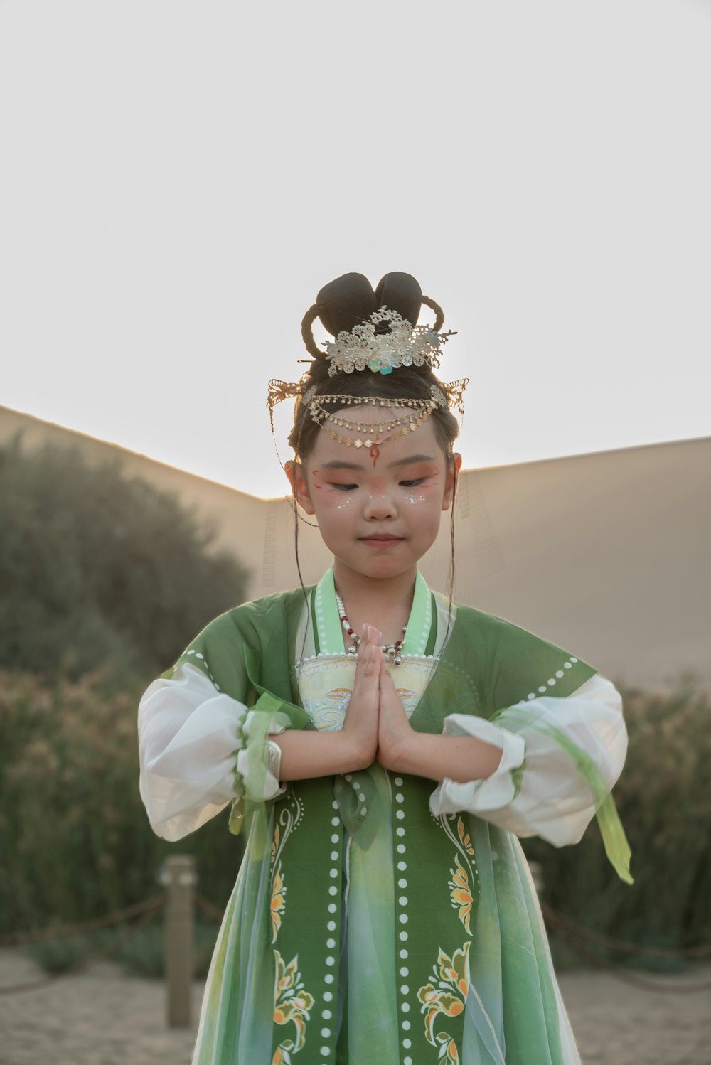 a young girl in a green and white dress