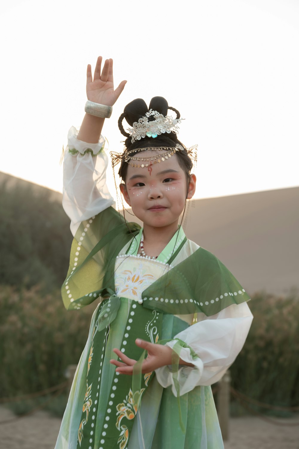 a little girl dressed in a green and white costume