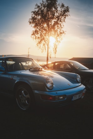 A gleaming classic muscle car parked under golden sunset light.