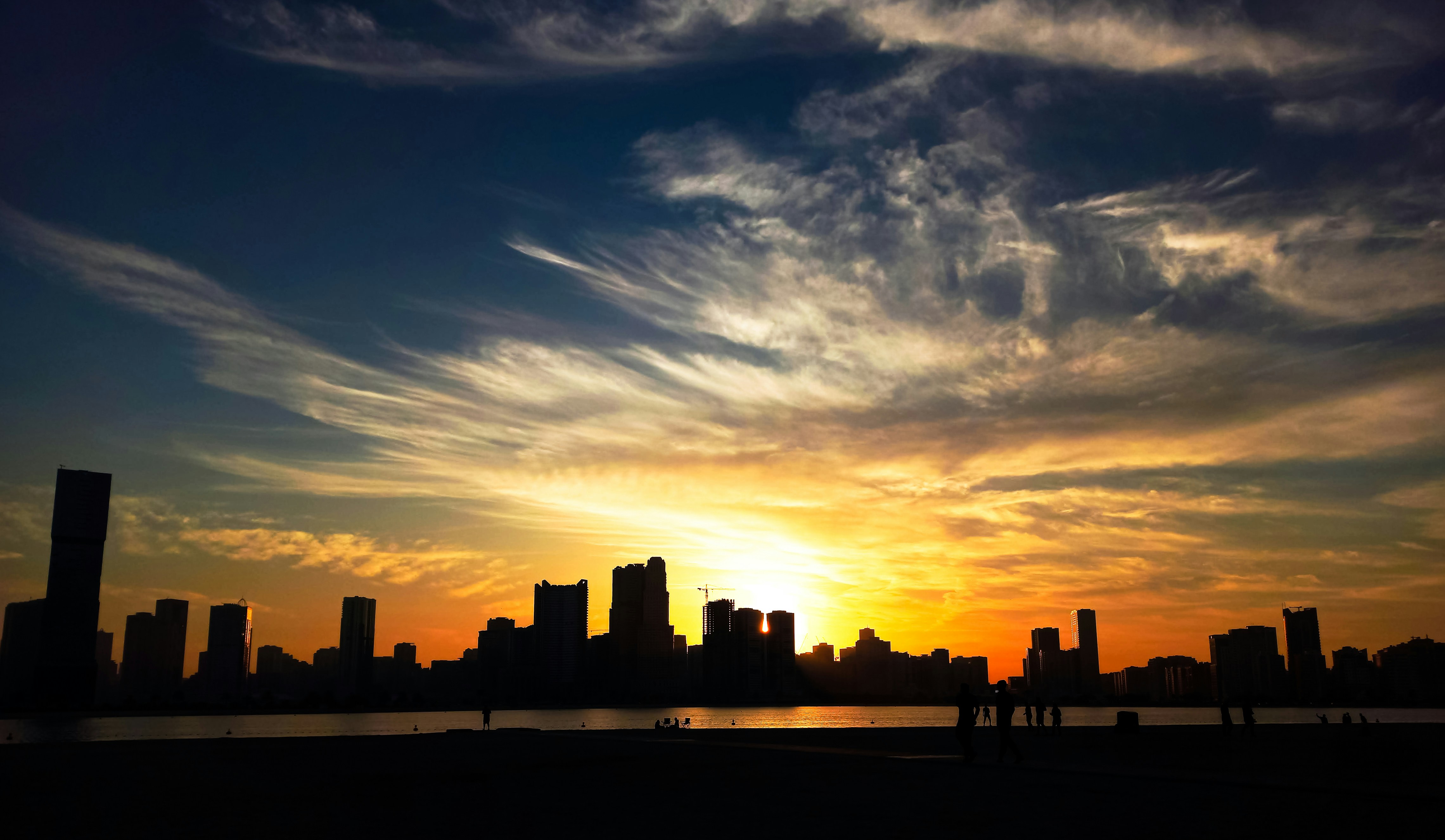 the sun is setting over a city with tall buildings