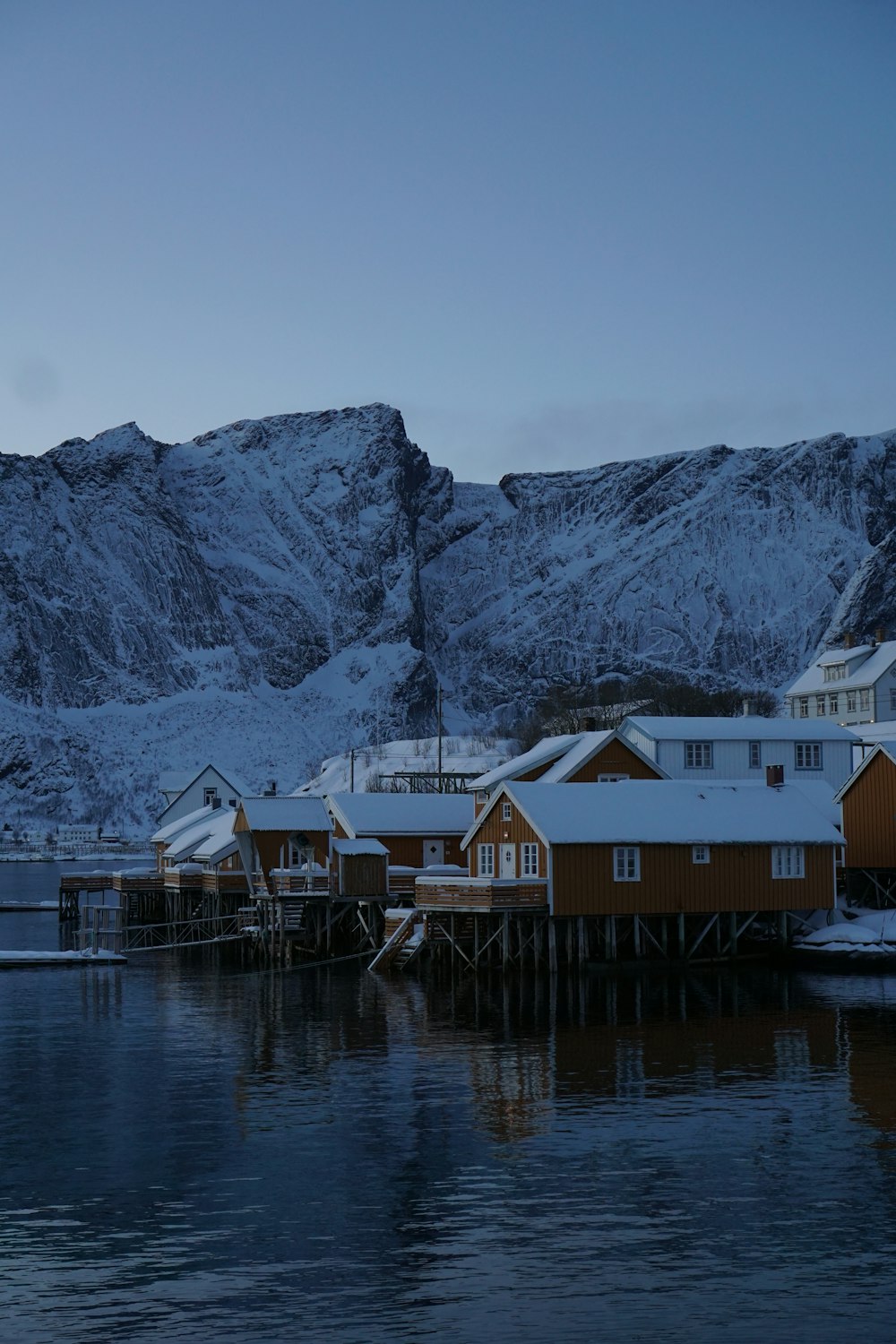 a group of houses sitting on top of a snow covered hillside