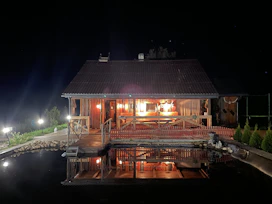 Chalet exterior at sunset with warm lights glowing from inside.