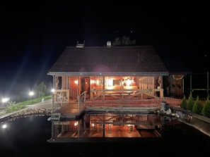 Night view of the cabin illuminated by warm outdoor lights.