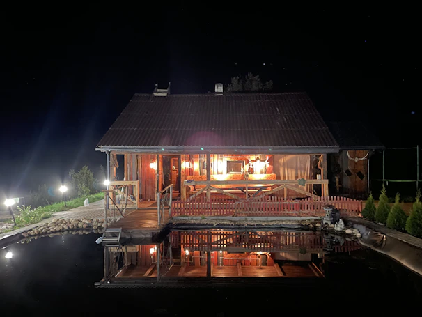 Chalet exterior at sunset with warm lights glowing from inside.