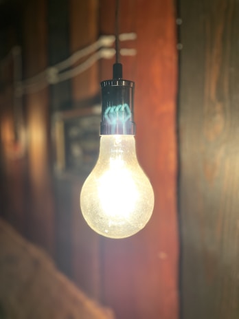 A bright, modern LED bulb glowing warmly in a cozy Indian home setting.