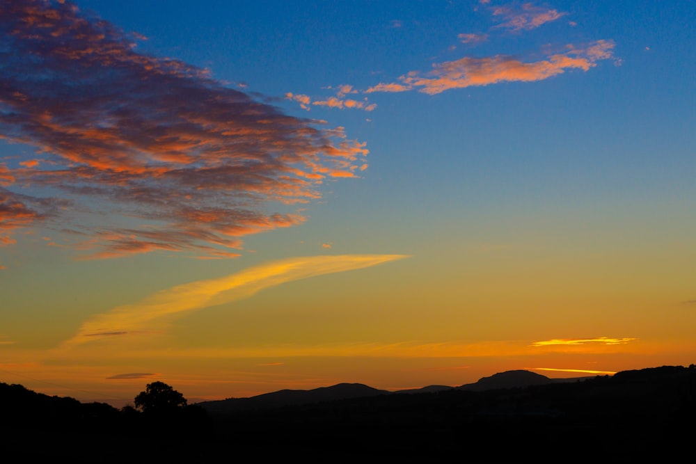 a plane is flying in the sky at sunset