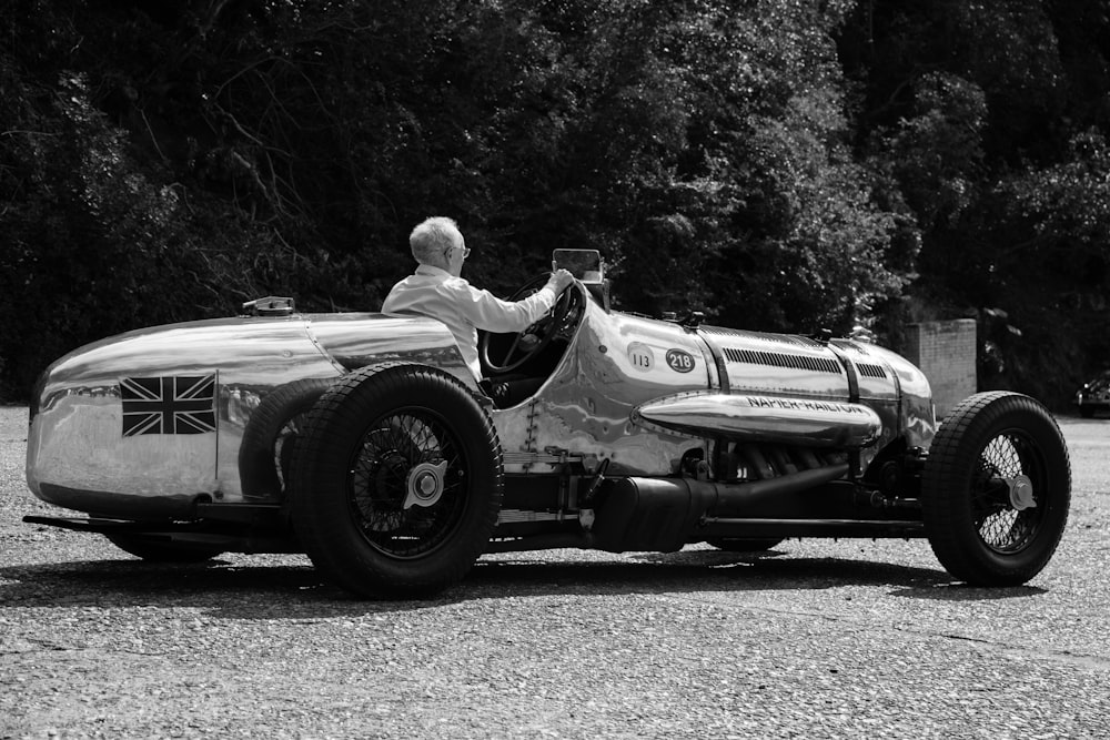 a man driving a race car on a gravel road