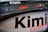 A close-up view of a vehicle part with the name 'Kimi Raikkonen' prominently displayed. The surface is sleek and shiny, with reflections indicating a polished finish. The text is printed in bold black letters with a red underline.