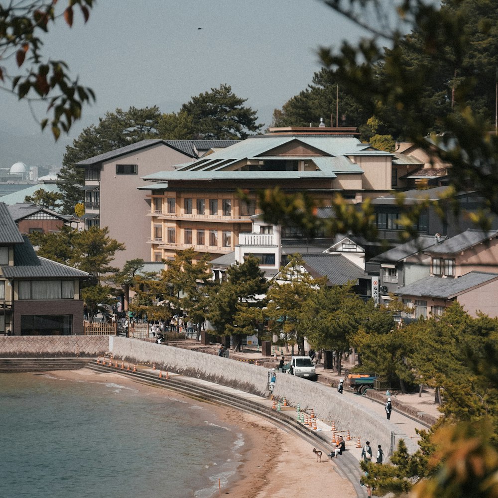 a group of people walking along a beach next to a body of water