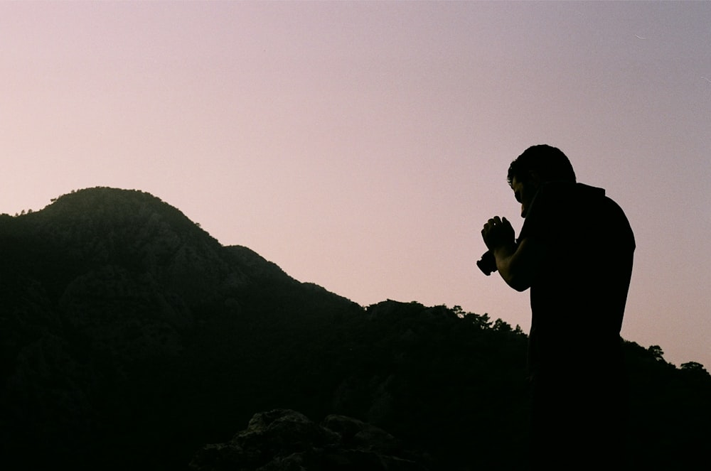 a man standing on top of a lush green hillside