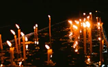 A collection of finished candles with soft flickering flames on a wooden table